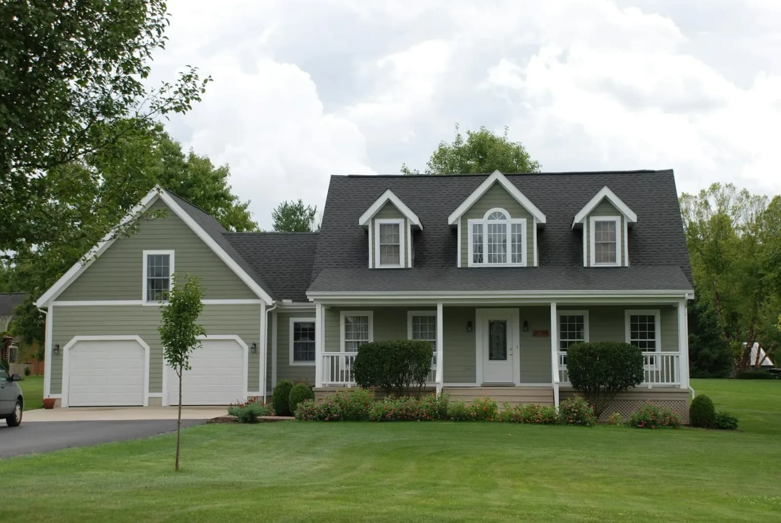 Two story home with clean light grey siding and white trim standing under an overcast sky